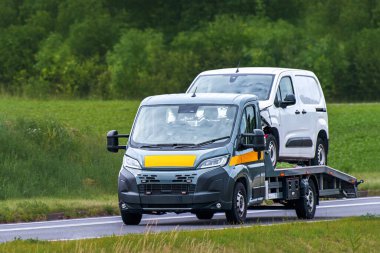 Vehicle recovery truck hauling car after collision