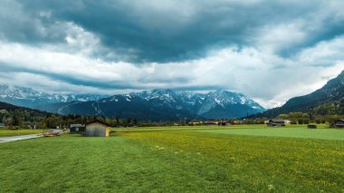 Huzurlu dağ çayırının üstündeki fırtınalı gökyüzü