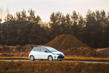 Çevre dostu araba, kır yolunda ilerliyor.