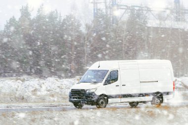 Ormanda karlı bir yolda ticari bir minibüs.