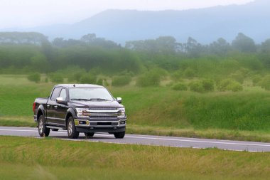 Yeşil kırsal çevreden geçen çok yönlü bir pikap