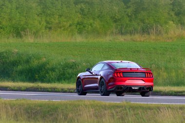 Yeşil arazide hızlı kırmızı araba.