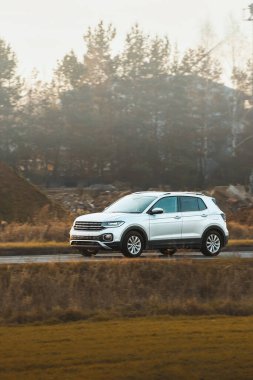 Gün batımında kırsal alanda gezinen arazi aracı.