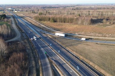 Beyaz lojistik kamyonu açık yolda hız yapıyor.