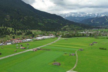 Bulutlu gökyüzünün altındaki renkli alp köyü
