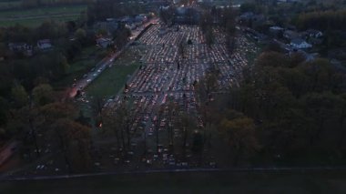 Mezar taşları karanlıkta mum ışığıyla çevrili.