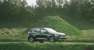 Orman manzarası yakınındaki yolda bir arazi aracı.