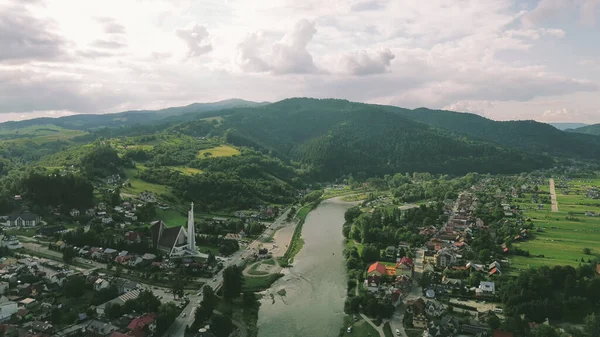 Dağ nehri yakınlarındaki yemyeşil orman ve tarım arazileri