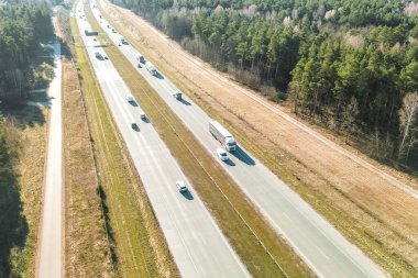 Yarı kamyon asfalt yolda gidiyor.