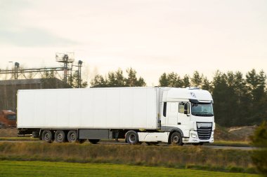 Kırsal arazide lojistik yarı kamyon sürüyor.