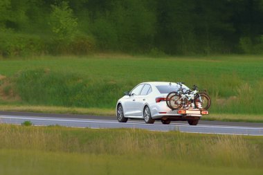 Sakin yol boyunca bisikletli bir araç sürüyor.