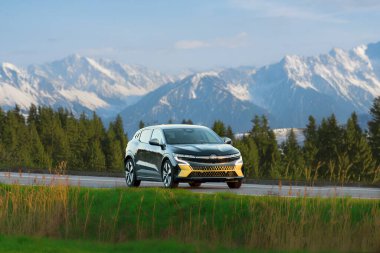 Elektrikli araba boş manzaralı yolda süzülüyor