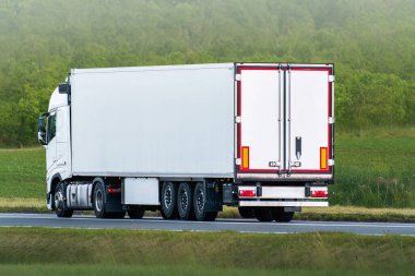 Kırsal yolda büyük beyaz bir kamyonet.