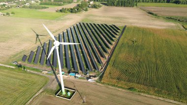 Modern rüzgar türbini ve mavi gökyüzünün altındaki güneş panelleri