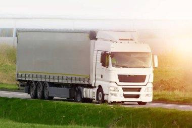 Kırsal bölgeden geçen beyaz kamyonet.