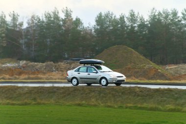 Çatısı açık havada giden aile aracı.