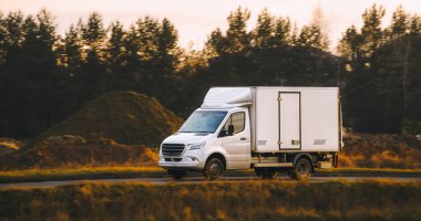 Doğal manzaralı bir nakliye aracı yolda.