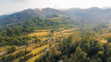 Nehir kenarındaki köy yeşil tepelerle çevrili.