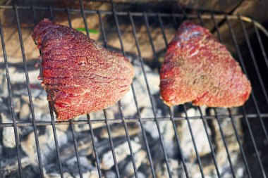 Angus bifteği açık barbekü ateşinin üstünde kızardı.