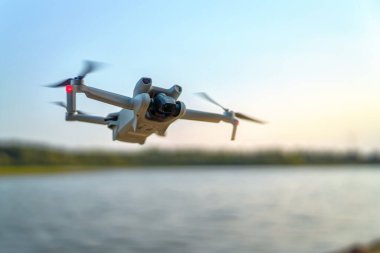 Quadcopter yaz akşamı suyun üzerinde süzülüyor.