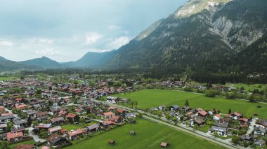 Karla kaplı Alpleri olan manzaralı kırsal