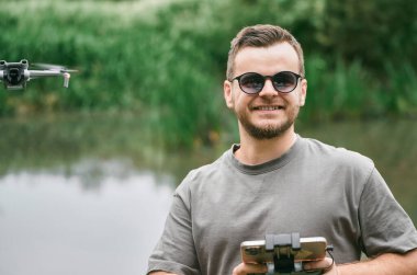 Göl kenarında uzaktan kumandalı gülümseyen adam.