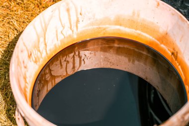 Kavanozda kullanılmış yağ, eski motor yağı, koyu renkli motor sentetik yağ.