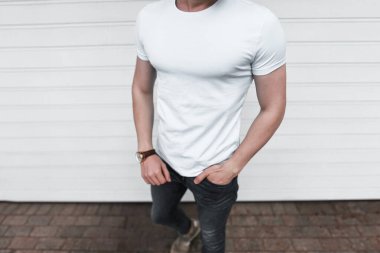 Beyaz tişört ve kot pantolon giyen bir erkek model.