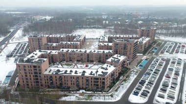 Karla kaplı çatıları olan yeni apartman kompleksi