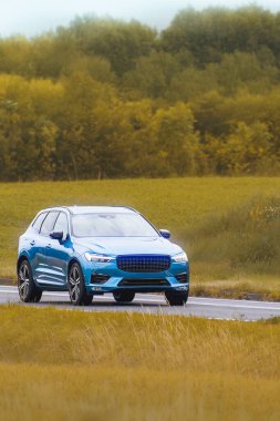 Açık yeşil alanlardan geçen zarif bir SUV.