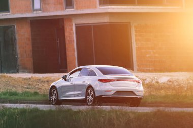 Boş köy yolunda elektrikli araba.