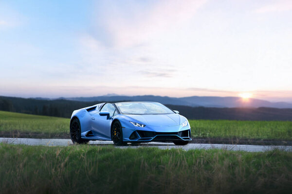 Sporty blue vehicle driving through nature