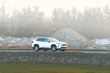 Çağdaş SUV yeşil kırsaldan geçiyor.