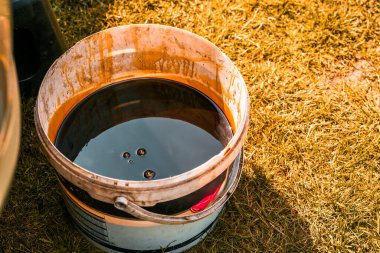 Atölye kovasında koyu renk motor yağı atığı