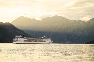 Köyün yakınındaki sakin sularda beyaz bir yolcu gemisi.