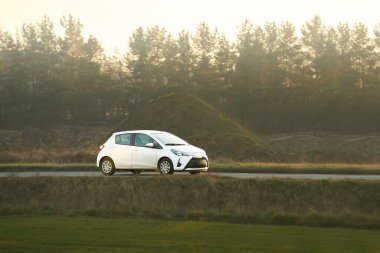 Modern hatchback arabası kırsal yolda seyahat ediyor.