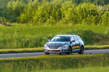 Köy yolunda geniş bagajı olan bir araba.