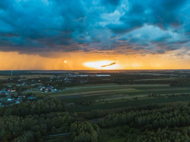 Kırsal kesimde gün batımı ve karanlık fırtına bulutları