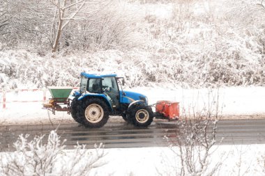 Şiddetli kar fırtınasında çalışan mavi traktör