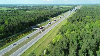 Yeşillik bir ormandan geçen kamyonları olan bir otoyol.