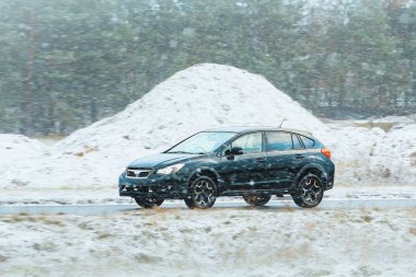 Karla kaplı dağ yolunda giden bir SUV.