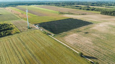 Fotovoltaik paneller ve mavi gökyüzünün altında rüzgar türbini