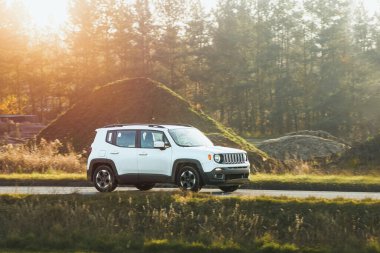 Huzurlu bir arazide lüks bir araç sürüyor.