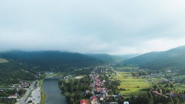 Sis ve bulutlar altında yeşil tepelerden oluşan hava manzarası