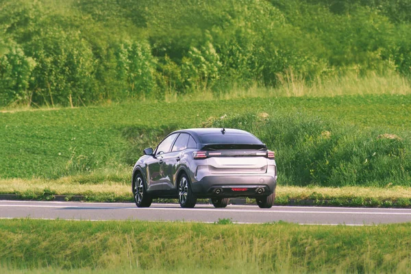 Manzaralı bir otoyolda hızlı giden bir SUV.
