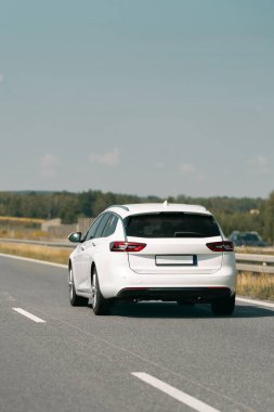 Beyaz arazi aracı temiz bir yolda ilerliyor.