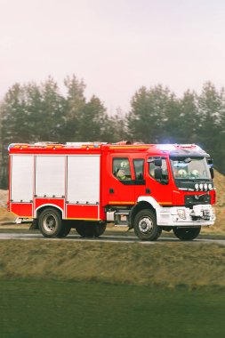 İtfaiyeciler kırmızı itfaiye aracında.