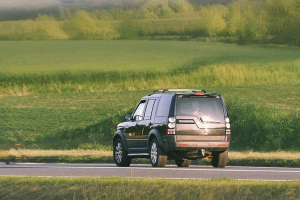 Fast SUV driving along quiet country road