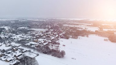 Kışın kar altında kırsal evler ve ormanlar