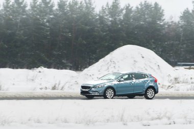 Soğuk karlı doğa sahnesinde araba sürüyor.